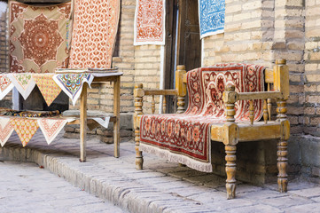 The wide range of the hand made carpets, traditional knotted Uzbek silk rugs, embroidered tablecloths and bed linen in the small bazaar, Khiva, Uzbekistan, Central Asia