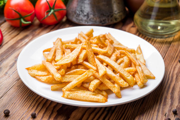 Tasty french fries on cutting board,  wooden table