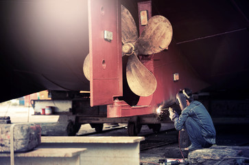 Welder man working in ship yard,color toned.