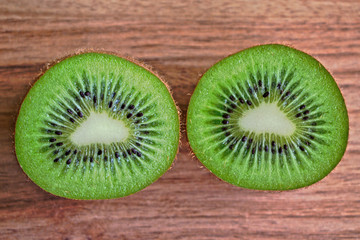 Closeup of two kiwi halves on a wooden table