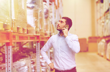 serious man calling on smartphone at warehouse