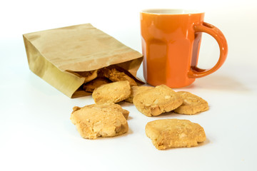Fototapeta na wymiar Cookies in paper bag and a cup of coffee