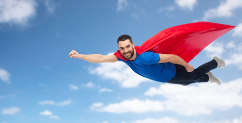 happy man in red superhero cape flying over sky © Syda Productions