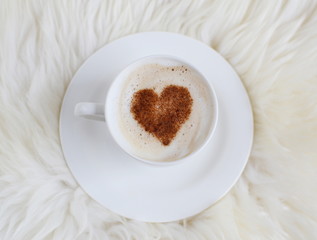 Cup of cappuccino with heart pattern of cinnamon