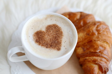 Cup of cappuccino with heart pattern of cinnamon