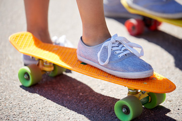 close up of female feet riding short skateboard