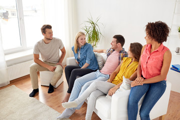group of happy friends talking at home