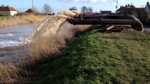 Flood water being pumped by huge pumps into river, in massive operation in Somerset UK to reduce flooding levels in nearby swamped villages.