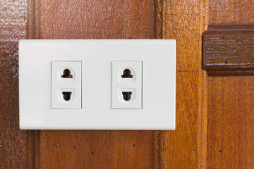 Power electric plug on the wooden wall