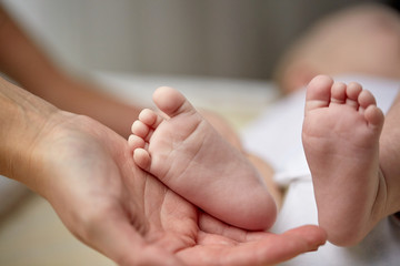 close up of newborn baby feet in mother hands