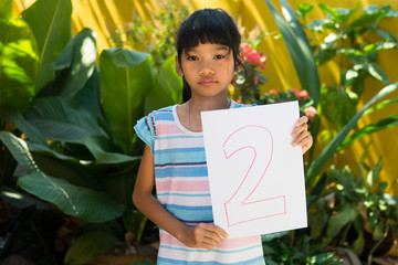 number concept,girl holding number two on white paper