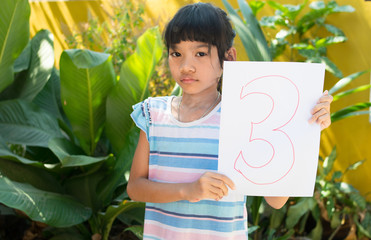 number concept,girl holding number three on white paper