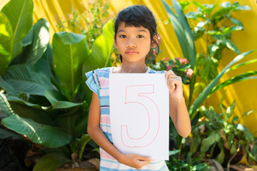 number concept,girl holding number five on white paper