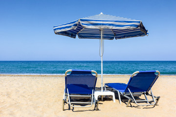 Sonnenschirm mit Liegen am Strand