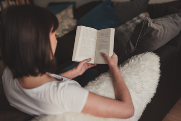 beautiful woman reading a book at home