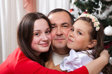 people, motherhood, family, christmas and adoption concept - happy father and daughter hugging at home