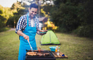 Happy male preparing bbq meat