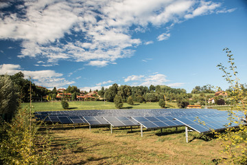 solar panel electricity central field in sunny day with blue sky and clouds