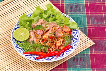Spicy and sour mixed herb salad with tuna served .