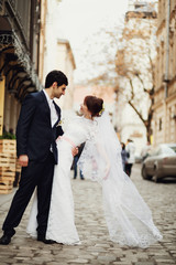 Naklejka premium bride and groom posing on the streets of the old city