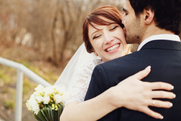 happy smiling bride hugging handsome groom, face closeup
