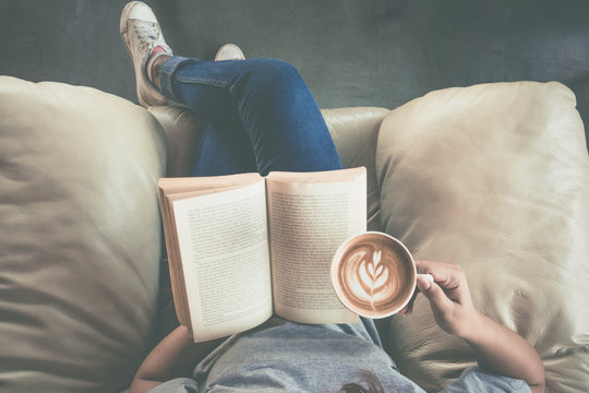 Soft photo of young girl reading a book and drinking coffee, top