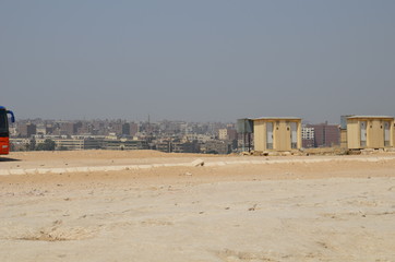 Pyramid in sand dust under gray clouds