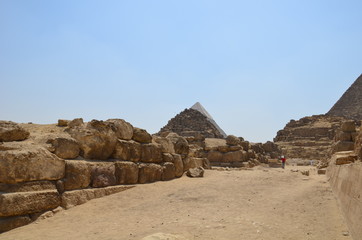 Pyramid in sand dust under gray clouds