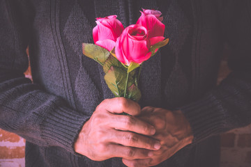 A man holding pink roses