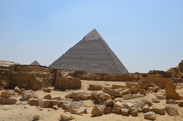 Pyramid in sand dust under gray clouds