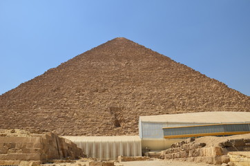Pyramid in sand dust under gray clouds
