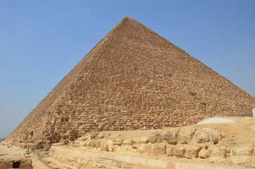 Fototapeta na wymiar Pyramid in sand dust under gray clouds