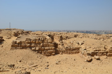 Pyramid in sand dust under gray clouds