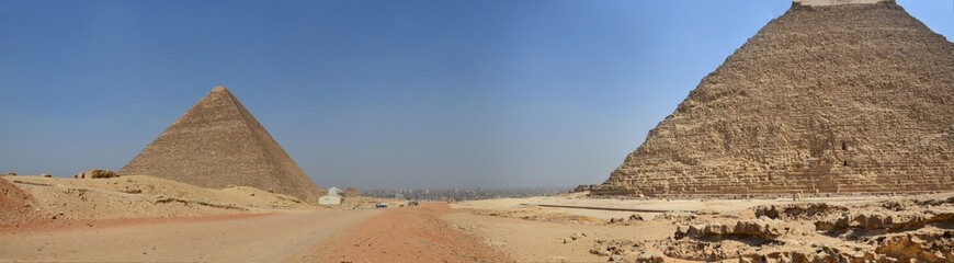 Pyramid in sand dust under gray clouds