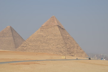 Pyramid in sand dust under gray clouds