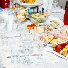 Wineglasses and cold cuts served on a table in restaurant