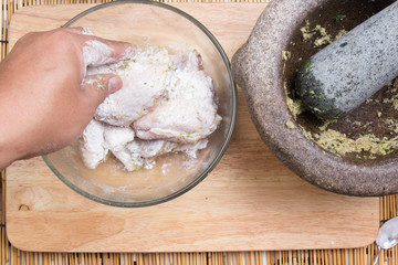 Chef mixing flour to chicken wings for cooking