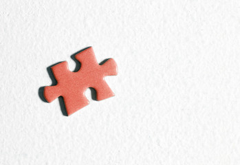 Red puzzle piece on a white surface.
