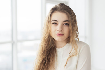 Beautiful young woman by window