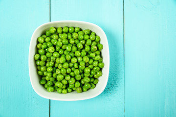 Fresh Green Peas In White Bowl On Turquoise Table