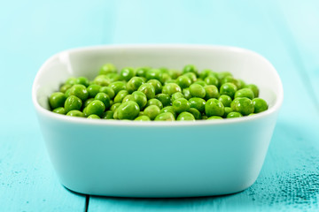 Fresh Green Peas In White Bowl On Turquoise Table