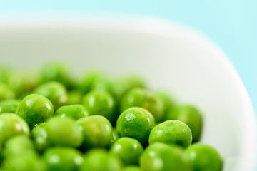 Fresh Green Peas In White Bowl On Turquoise Table