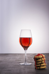 Glass of red wine with stack of cookies with red ribbon