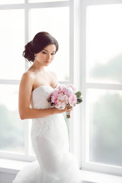 Stunning young bride holding bouquet