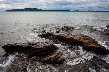 Sea waves lash line impact rock on the beach