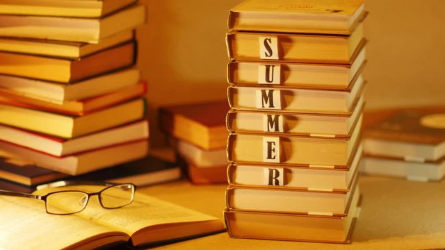 Stack of books with an inscription SUMMER BOOK. Stop motion