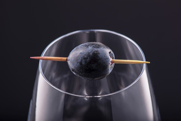 Red grape in a stick on empty glass- close up; conceptual image