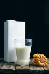 Tasty cookies and glass of milk on wooden background