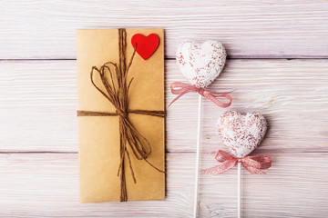 Love letter and decorative hearts on wooden background