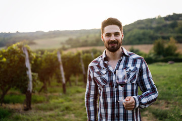 Winegrower tasting wine in vineyard